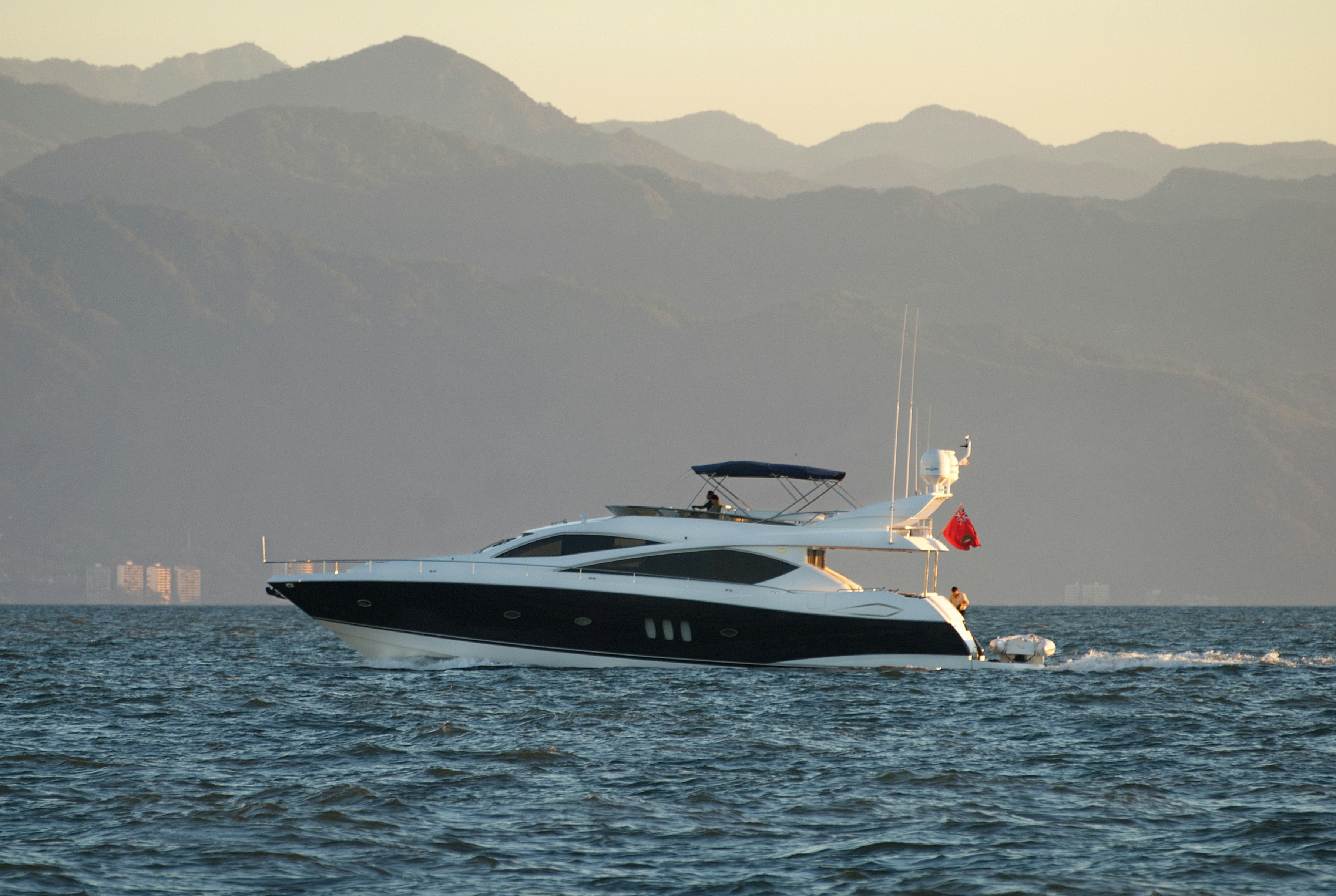 A flybridge motor yacht cruising at dusk, shown as an illustrative reference